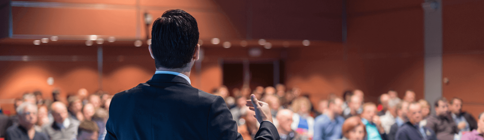 man at conference giving talk to full room